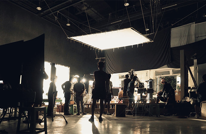 Film crew working on set in a studio.