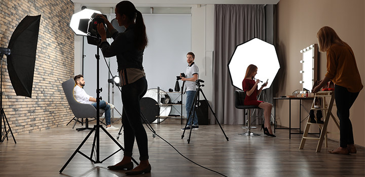 Studio portrait session with photographers, models, and assistants.