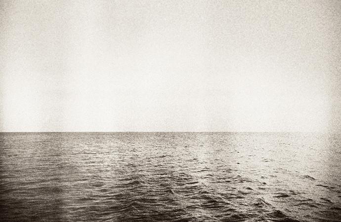 Black and white photo of ocean with film grain effect.