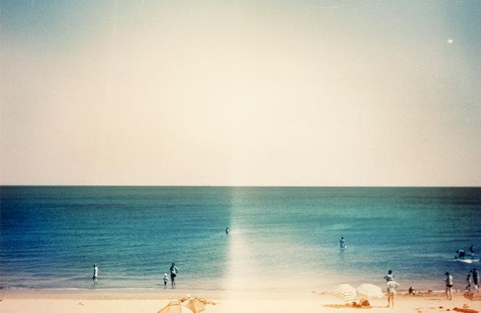Film grain picture of beach and ocean with light leaks