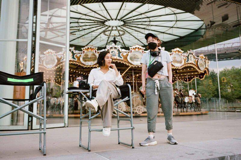 Director Celine Strong and actress Greta Lee filming Past Lives in front of Jane’s Carousel in New York City. Image © A24